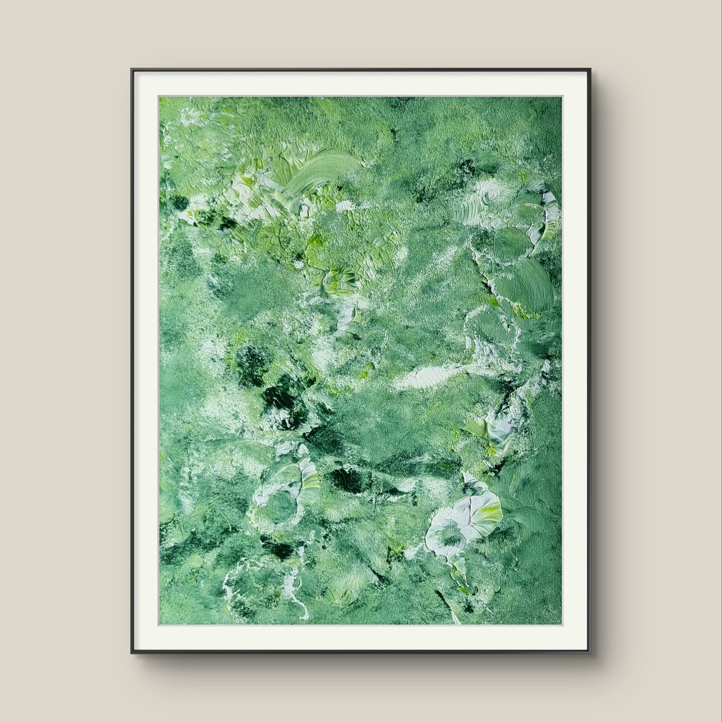Green and white abstract painting in a black frame against a grey background created by up-and-coming artist Jeanette Haga as decor for modern homes