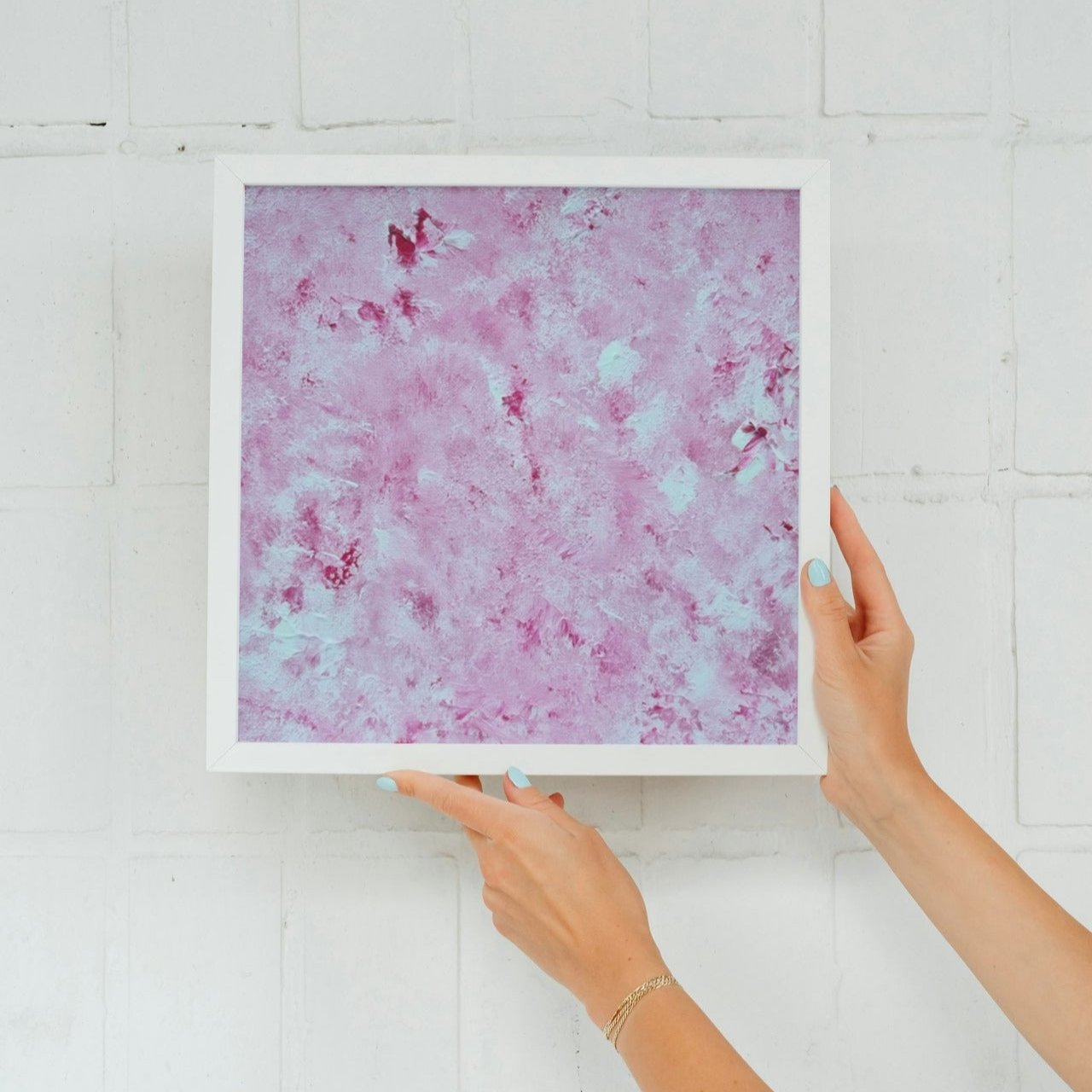 Vibrant Red and white Feel good one of one-of-a-kind colorful art poster based on original abstract art created by up-and-coming artist Scandinavian Jeanette Haga as decor for modern home held towards a white wall
