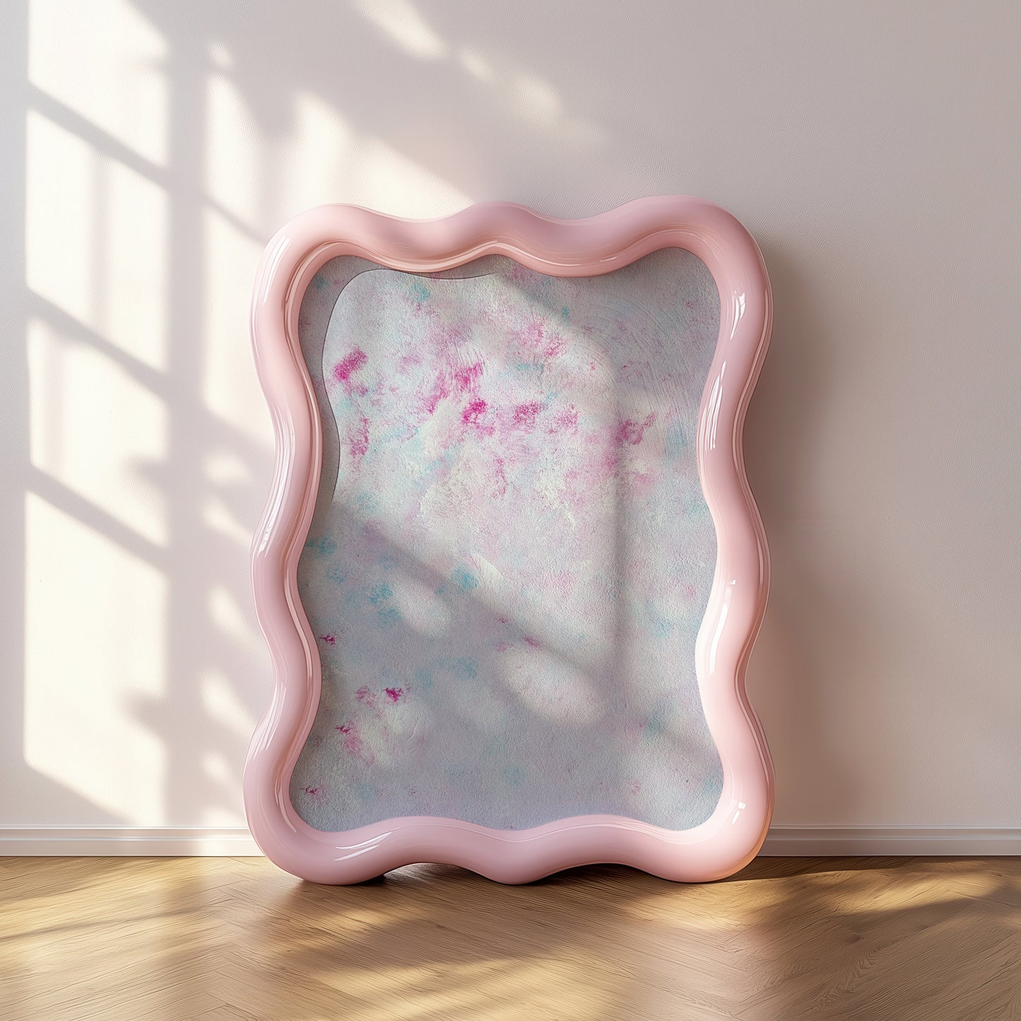 A wavy-edged pink mirror leaning against a light beige wall on a wooden floor, with soft window shadow patterns cast across the reflective surface.