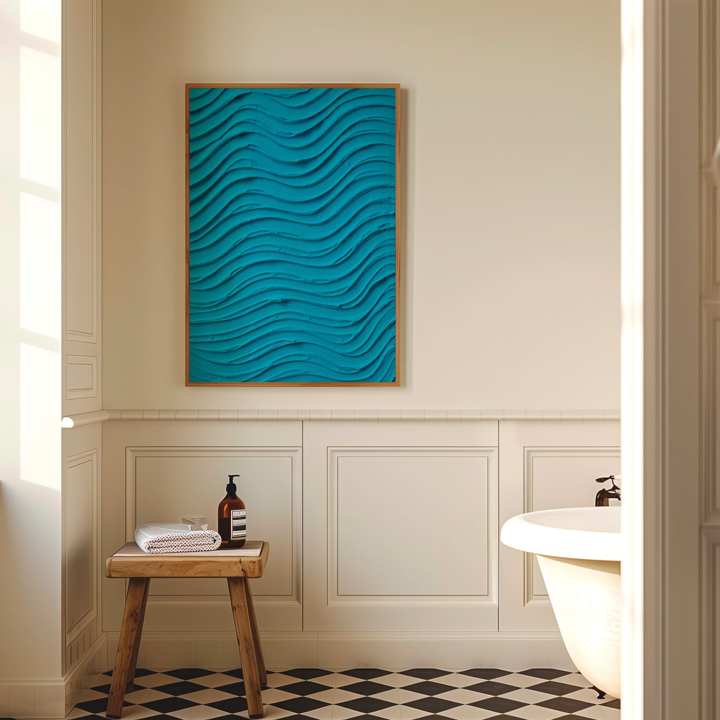 A vertical framed wall art piece with a bright turquoise blue wavy 3D texture, displayed in a warm, neutral-toned bathroom setting above a small wooden stool.