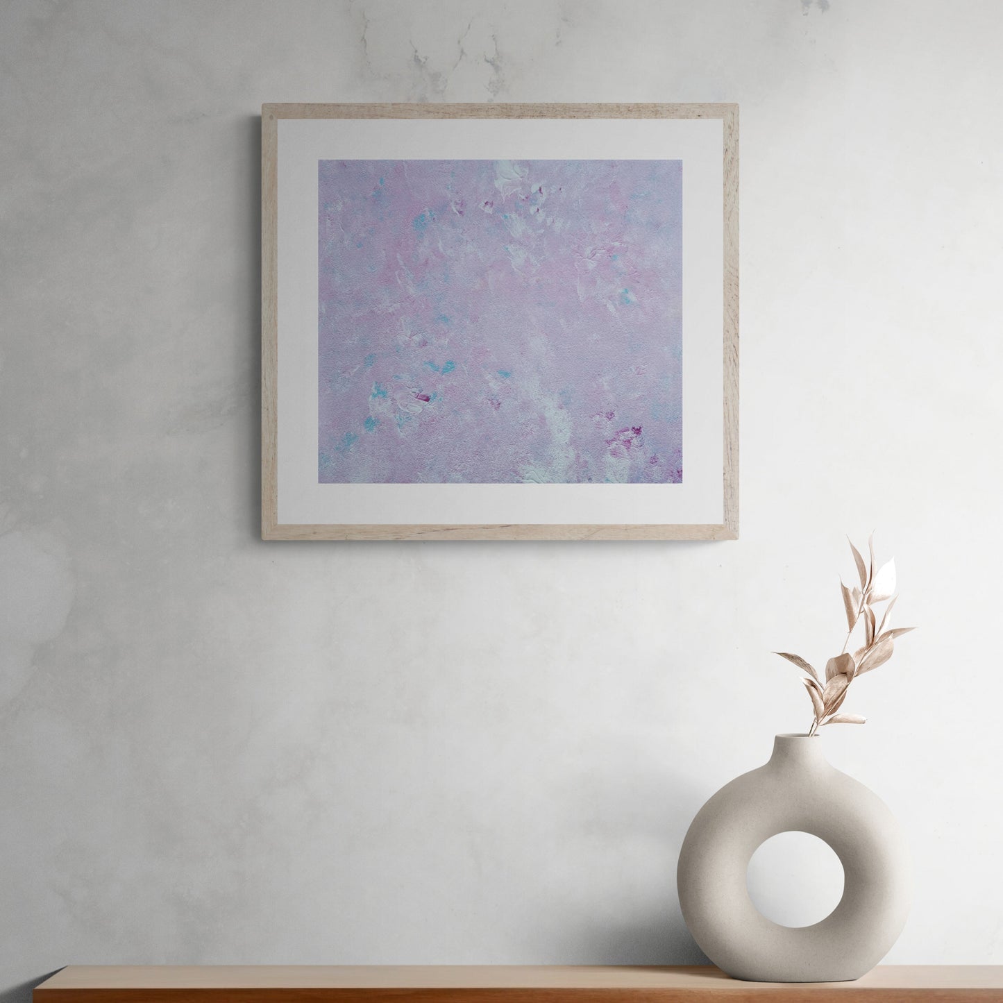 Pastel pink, baby blue, and white abstract art poster hanging on a grey wall, created by up-and-coming artist Jeanette Haga as decor for modern homes