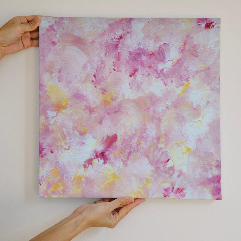 pastelpinkandyellow Feel good one of one-of-a-kind colorful art poster based on original abstract art created by up-and-coming artist Scandinavian Jeanette Haga as decor for modern home held against a white wall
