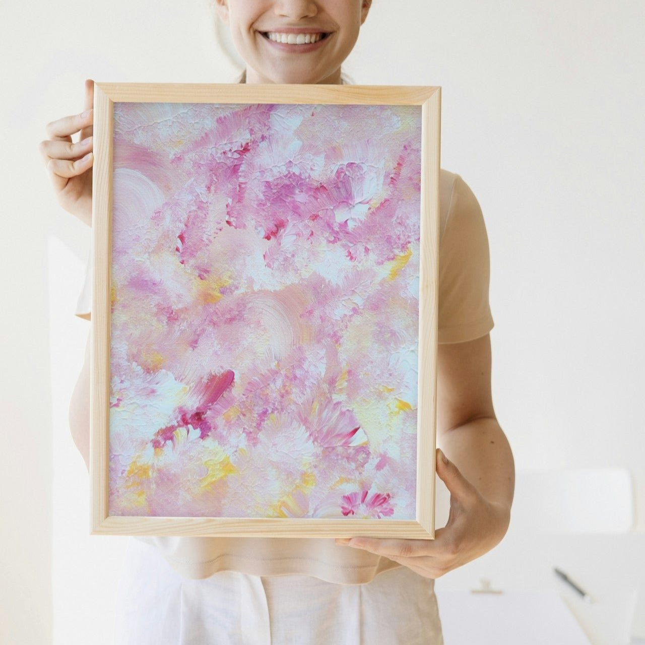 pastelpinkandyellow Feel good one of one-of-a-kind colorful art poster based on original abstract art created by up-and-coming artist Scandinavian Jeanette Haga as decor for modern home held by a woman