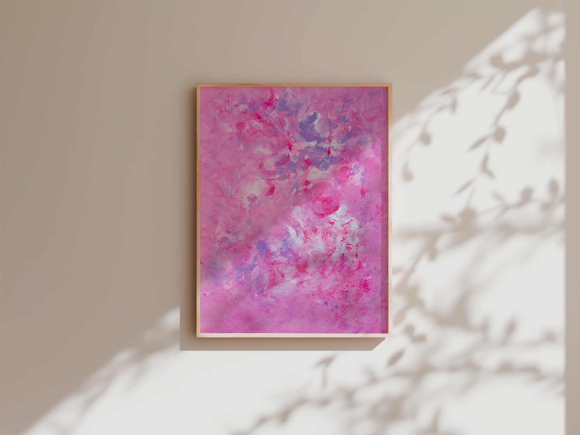 pink art poster hanging on a white wall with daylight