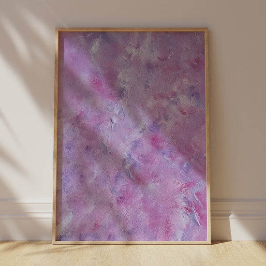 pink and purple bstract art poster leaning agains white wall